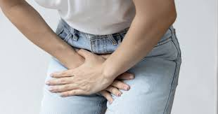 Woman post 40 holding her pelvic muscles in discomfort