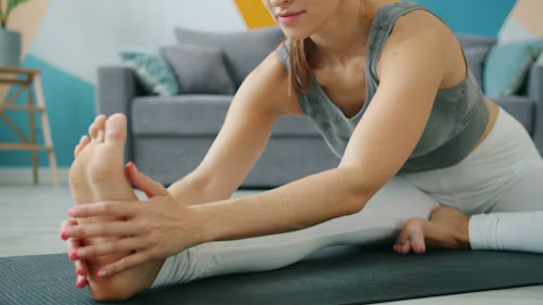 A woman doing yoga poses in her living area
